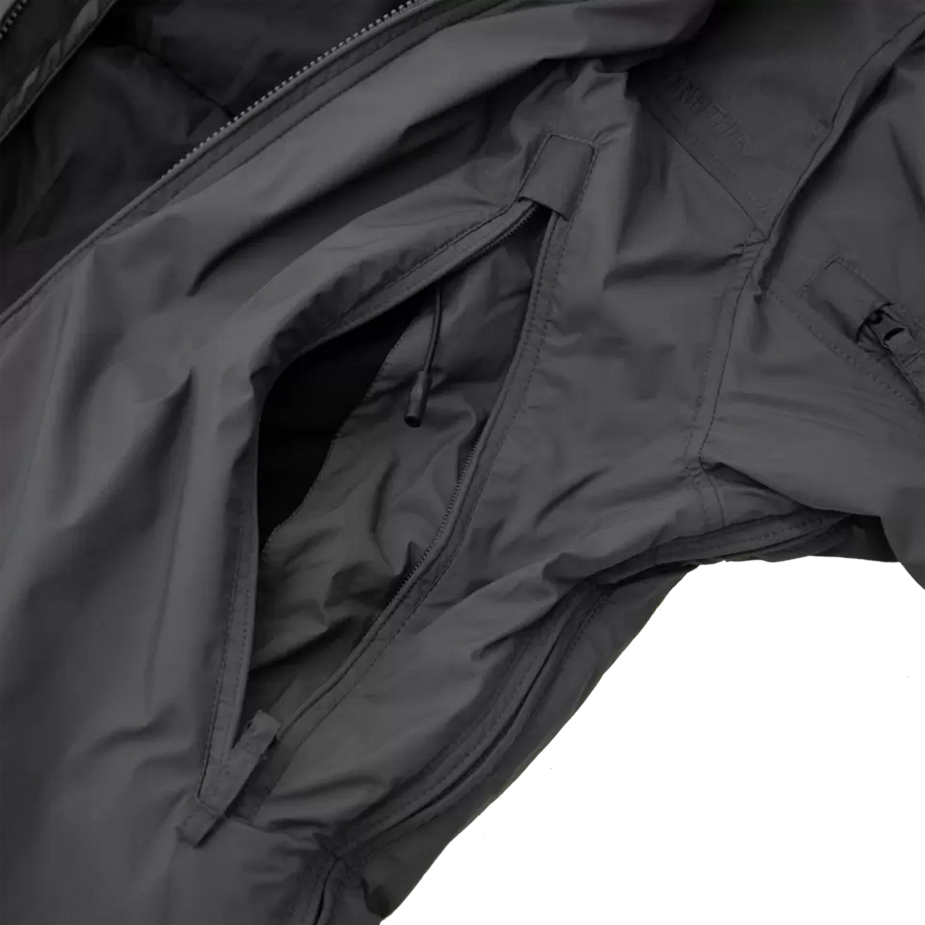 Nahaufnahme einer grauen Carinthia-Einsatzjacke mit Brusttasche mit Reißverschluss und strapazierfähigem, wetterbeständigem Material.