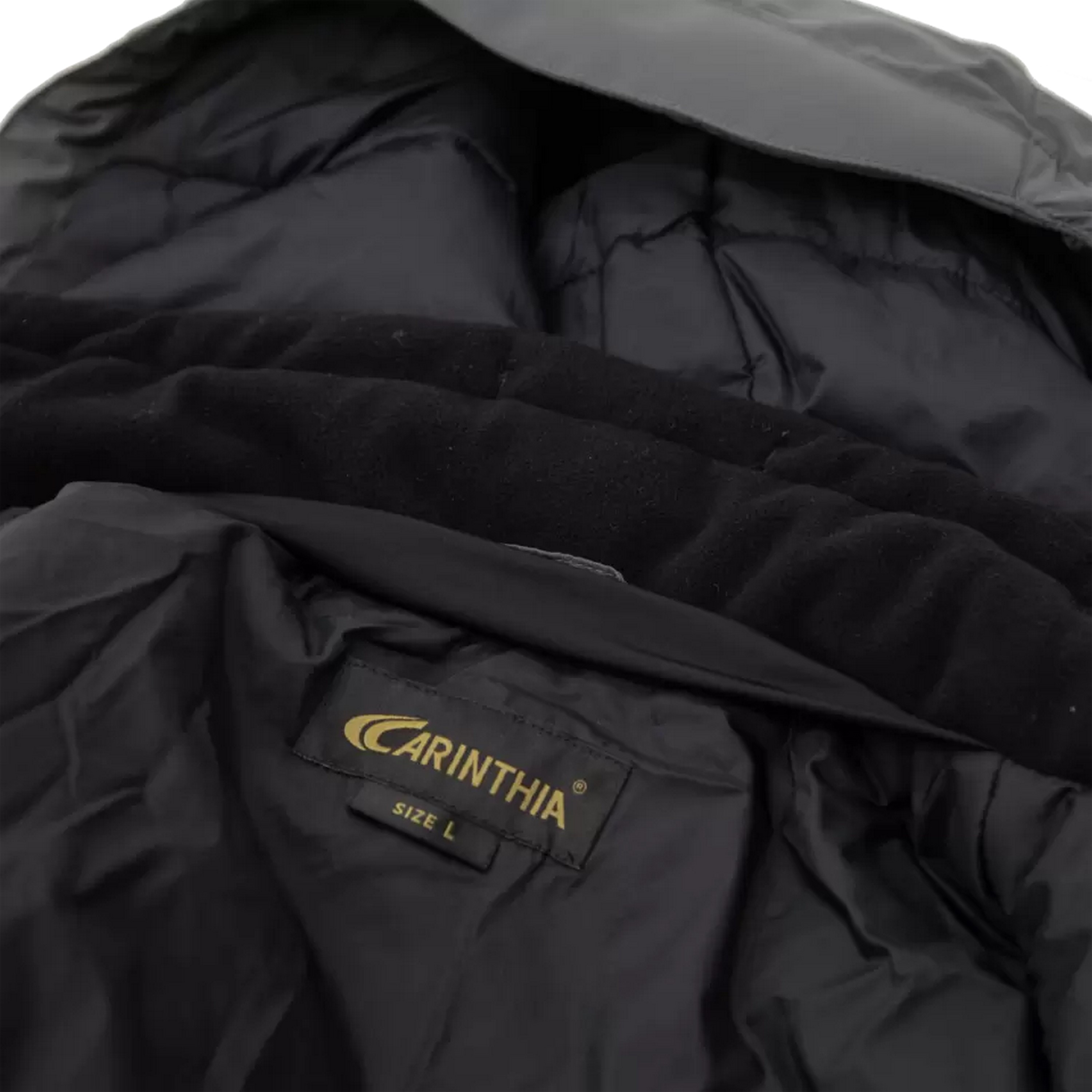 Nahaufnahme der Innenseite einer schwarzen taktischen Carinthia-Jacke mit Markenetikett, Größe-L-Tag und gesteppten Futterdetails.