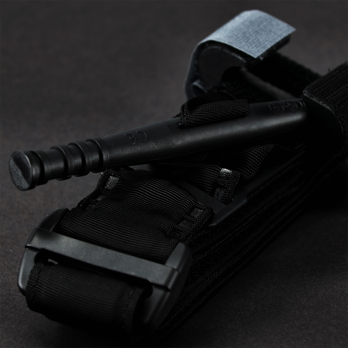 Schwarzes taktisches Tourniquet mit einer starren Ankerwindenstange und einem robusten Riemen zur Notfallkontrolle von Blutungen und Traumata.