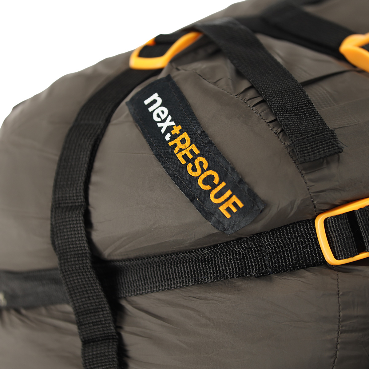 Nahaufnahme einer dunkelolivfarbenen nex+RESCUE-Tasche für taktische Ausrüstung mit schwarzen Nylonriemen und leuchtend orangefarbenen Kunststoffschnallen.